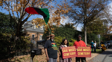 People holding signs in support of Moses Cemetery